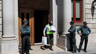 Un agente de la Guardia Civil sacando documentos del Ayuntamiento de Reus el pasado martes. Foto: Alba Mariné