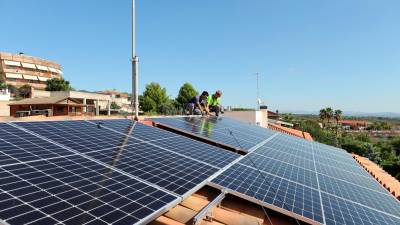 Dos operarios ultiman la instalación de paneles fotovoltaicos en el tejado de un domicilio en Castellvell del Camp. Foto: Alba Mariné