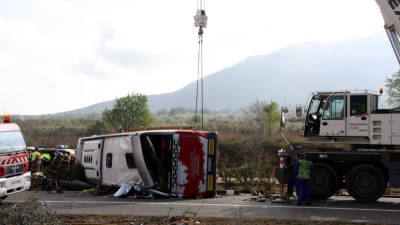 Una grua aixecant l'autocar accidentat a l'AP-7 a Freginals (Montsià), el 20 de març del 2016. Foto: ACN