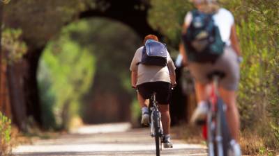 Dos personas haciendo cicloturismo por la Vía Verda. FOTO: joan revillas