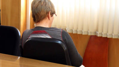 L'acusada, Remei Barrera, asseguda d'esquenes al banc dels acusats de l'Audiència de Tarragona. Foto: ACN