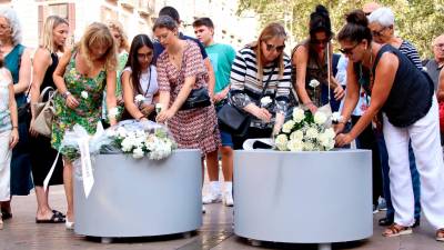 Momento en que los familiares y víctimas han depositado las flores en las jardineras de la Rambla. Foto: ACN