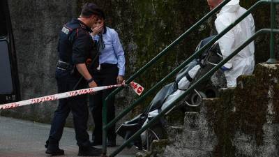 Los servicios funerarios trasladan de la vivienda el segundo de los dos cuerpos. foto: EFE