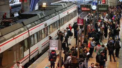 Varias personas esperan la llegada de su tren de Cercanías este viernes en la estación de Atocha durante la huelga de los trabajadores de Renfe y Adif de 23 horas. Foto: EFE