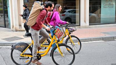 Dos usuarios utilizando la bici pública compartida la Ganxeta. FOTO: Alfredo González