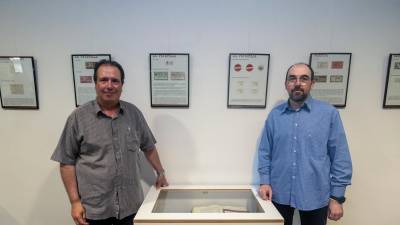 Els historiadors Pere Rams i David Tormo amb una mostra sobre paper moneda a l’Arxiu Comarcal de la Terra Alta. foto: joan revillas
