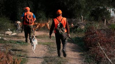 Una parella de caçadors es preparen per la primera cacera solidària a Vilabella. Foto: ACN