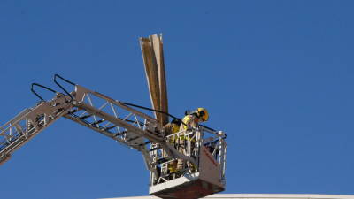 Los bomberos, retirando elementos de la cubierta. Foto: Àngel Juanpere