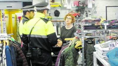 Els agents de la Policia Local parlant amb una de les comerciants que hi ha al carrer Barcelona.