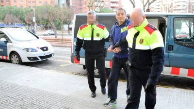 Dos agentes durante el traslado de un detenido al Juzgado de Guardia de Tarragona. Foto: Lluís Milián