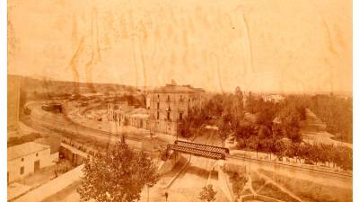 L’avinguda amb el pont original del ferrocarril que la travessava i el parc municipal a la dreta, a finals del segle XIX. Foto: Autoria desconeguda/ ACBE