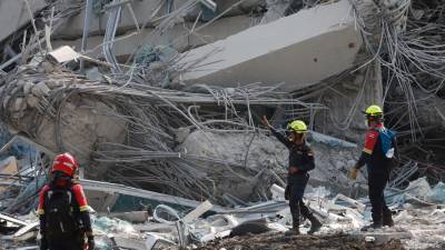 Más de una decena de excavadoras y grúas retiran con sumo cuidado los enormes bloques de cemento. Foto: EFE