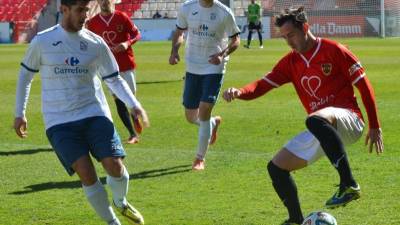 Un jugador de la Pobla controla el balón ante un rival 'potablava' ayer en el Nou Estadi. Foto: José Maria García