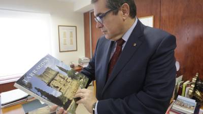 El conseller d´Interior mirant un llibre sobre la ciutat de Tarragona a la seu de la delegació del Govern a Tarragona, on va concedir l´entrevista al ´Diari´. FOTO: ÀNGEL JUANPERE FOTO:LLUÍS MILIÁN