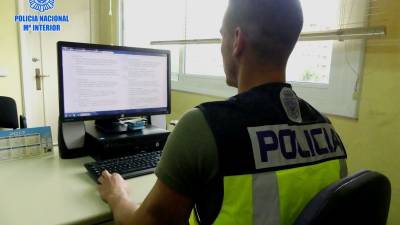 Un agente de la Policía Nacional mirando en su ordenador la web en la que el detenido intertaba sus anuncios. FOTO: DT