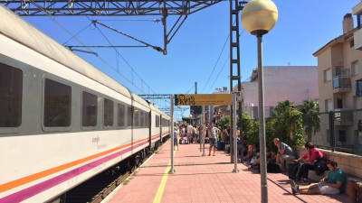 Pla general dels passatgers esperant a l'estació de l'Ampolla al costat del tren de l'R16 avariat, el 22 d'agost del 2016.