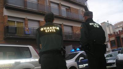 Guardia Civil y Policía Local custodian el tapiado de pisos en un bloque ocupado. FOTO: DT