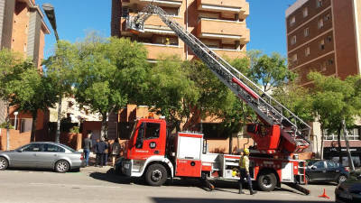 Los bomberos retirando los azulejos que amenazaban con caer a la calle. Foto: Àngel Juanpere
