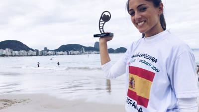 Marina Campos posa con el título logrado en la playa de Copacabana, Brasil. FOTO: CEDIDA