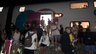 Imagen de los pasajeros fuera del tren tras permanecer parados durante más de dos horas. Foto: Alberto Puchades