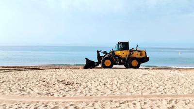 Una de las excavadoras que ayer por la mañana estaba repartiendo la arena que procede de la playa del Vinyet. FOTO: Ajuntament d’Altafulla