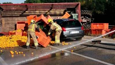 Vuelca un tractor con un cargamento de naranjas y provoca una colisión con un coche