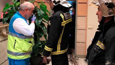 Fotograf&iacute;a cedida por la Comunidad de Madrid de un miembro del SUMMA y varios bomberos en la puerta de la vivienda en la que dos menores han sido encontrados muertos