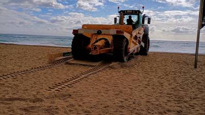 La máquina acumula arena junto a los captadores de la playa.