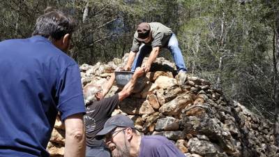 Voluntarios reconstruyen una barraca de piedra en La Bisbal.