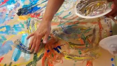 Una cuidadora pinta con las manos en el taller de arteterapia del Centre Cívic de Sant Pere i Sant Pau. Foto:Dominika Dittwald/cedida