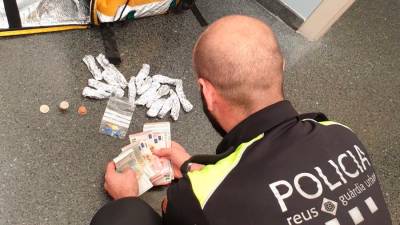 Un agente de la Guàrdia Urbana de Reus con la droga y el dinero incautado. Foto: @reusgurbana