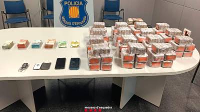La droga intervenida, junto al dinero encontrado en los dos coches. Foto: Mossos d’Esquadra