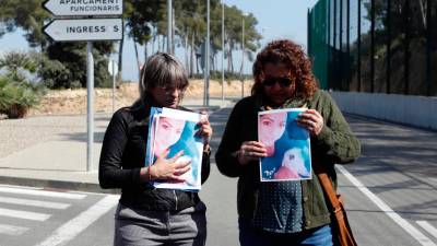 Dos compañeras de Núria muestran unaa foto de la compañera asesinada este pasado miércoles. Foto: Marc Bosch