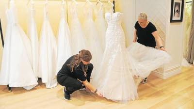 Dos empleadas de la tienda Pronovias de Reus arreglando un vestido de novia esta semana. Foto: Alba Mariné