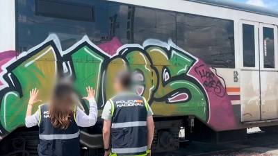 Dos agentes analizando las pintadas de uno de los vagones. Foto: CNP
