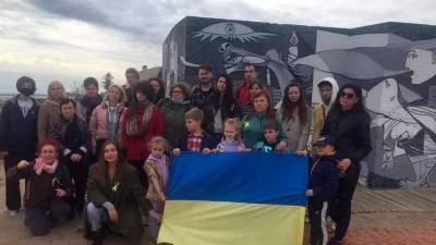 Ucranianos acogidos en El Vendrell junto al mural del Gernika. foto: DT