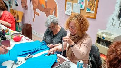 Preparando baberos de calçotada en el taller Activa’t. Foto: AVV El Santuari