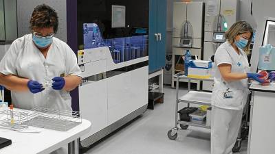 Dos sanitarias manejan muestras en el laboratorio del Joan XXIII. FOTO: ICS
