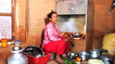 Una dona nepalesa cuinant en una de les cuines amb xemeneia construïda en el marc del projecte impulsat per Awasuka. FOTO: CEDIDA