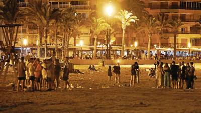 Grupos de jóvenes realizando botellones en la playa de Llevant de Salou, junto al Passeig Jaume I, esta semana. FOTO: pere ferré