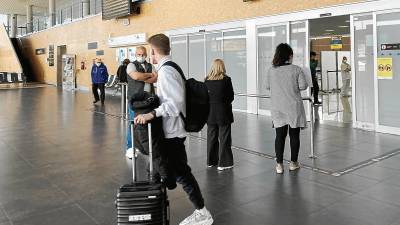 Una imagen de viajeros caminando con sus maletas por el interior del edificio del Aeropuerto de Reus, en la zona de llegadas. Foto: Alfredo González