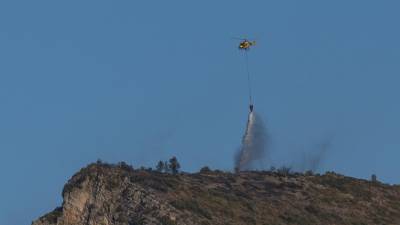 Un helicòpter, descarregant aigua sobre el perímetre del foc. FOTO: JOAN REVILLAS