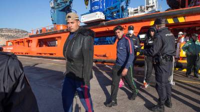 Agentes de polic&iacute;a nacional custodian el desembarco de los 48 inmigrantes argelinos rescatados ayer en aguas de Cartagena. FOTO: EFE
