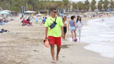 Un socorrista caminando este verano por la playa de Ponent de Salou. Foto: Alba Mariné / DT