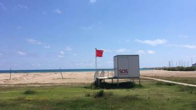 En la playa ondea la bandera roja.