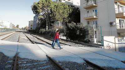 La antigua línea del tren a su paso por Salou se transformará en el Eix Civíc. En la foto, dos personas cruzando hacia la calle Barenys, en el barrio de La Salut. FOTO: PERE FERRÉ