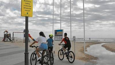 Tres jóvenes ciclistas circulan a velocidad lenta por el paseo marítimo de Torredembarra. FOTO: Anna F.-Ayto. Torredembarra