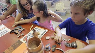 Los niños que participaron en el taller trabajando con las piezas arqueológicas que han encontrado excavando con la ayuda de sus monitores. Foto: LUÍS MILIÁN