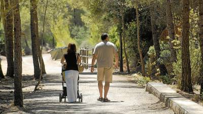 Una pareja con un carrito de bebé paseando por la Vía Verda, cerca del municipio de Benifallet. FOTO: Joan Revillas