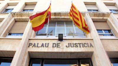 Pla contrapicat de la façana d'entrada a l'Audiència de Tarragona, amb el rètol de 'Palau de Justícia' i les banderes espanyola i catalana. FOTO. ACN